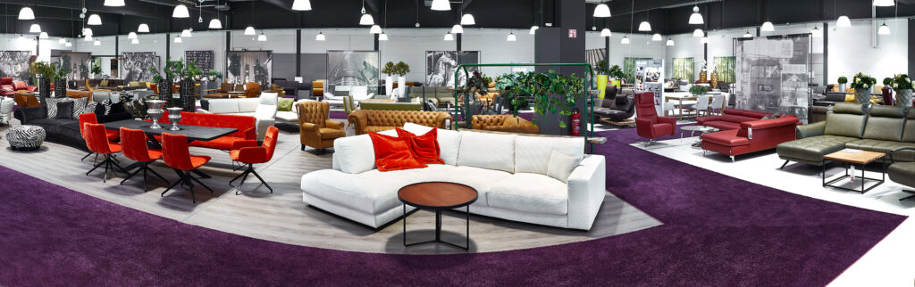 Panoramaansicht Multipolster Filiale Innen mit verschiedenen Sofas, Tischen und Stühlen in stylischer Einrichtung.