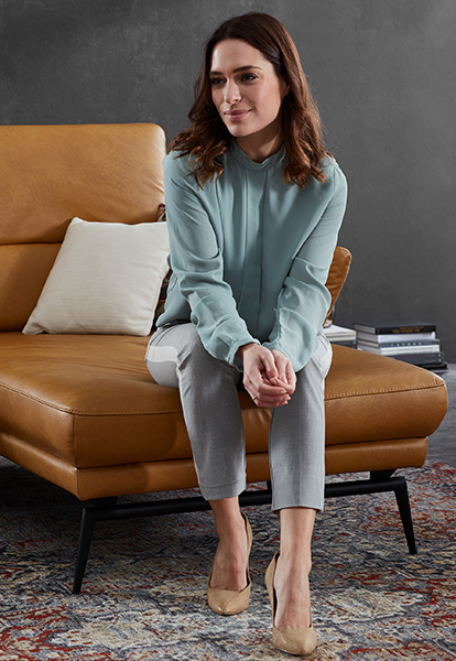 Sofa in Leder orange mit einer sitzenden Frau